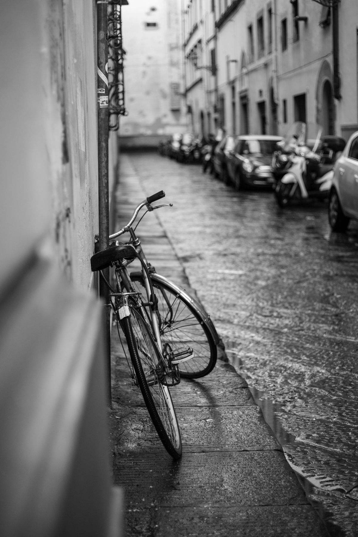 A bicycle parked on a wet city street